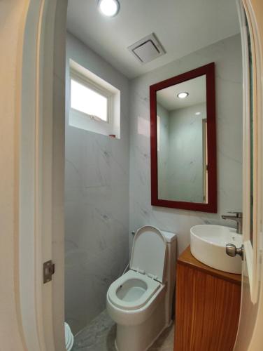a bathroom with a toilet and a sink and a mirror at DMC Condotel in Puerto Princesa City