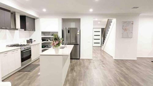 a kitchen with white cabinets and a white counter top at Elegant 5 Bed Brand New Spacious House in Clyde