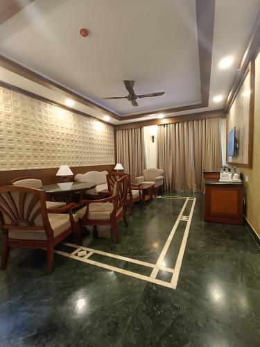 a dining room with tables and chairs and a tv at Tea county in Munnar