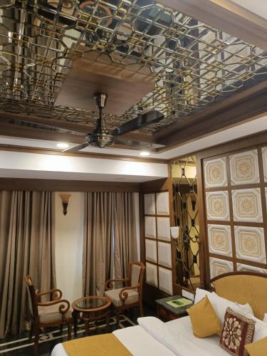 a room with a bed and chairs and a ceiling at Tea county in Munnar