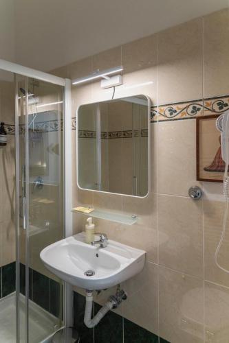 a bathroom with a sink and a shower and a mirror at Affittacamere Zanobi 45 in Florence