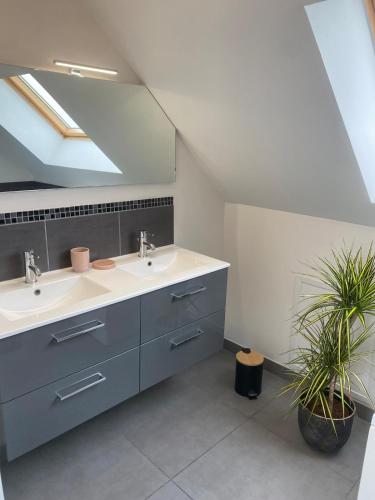 La salle de bains est pourvue de deux lavabos et d'une lucarne. dans l'établissement Gîte de l'Epinay Cassis, à Saint-Saëns