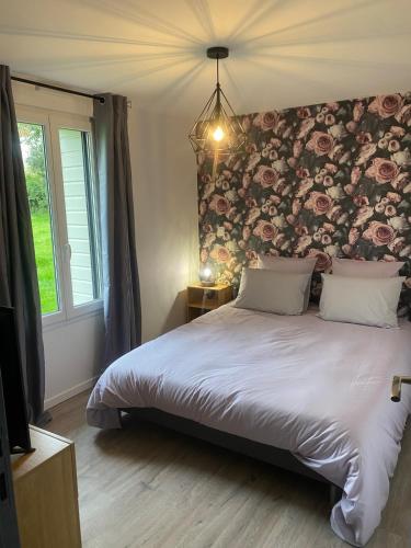 - une chambre avec un grand lit et un mur fleuri dans l'établissement Gîte de l'Epinay Cassis, à Saint-Saëns