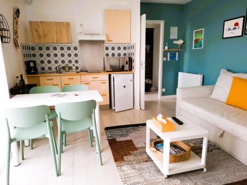 a kitchen and living room with a table and a couch at Les Hauts de Perpigna in Royan