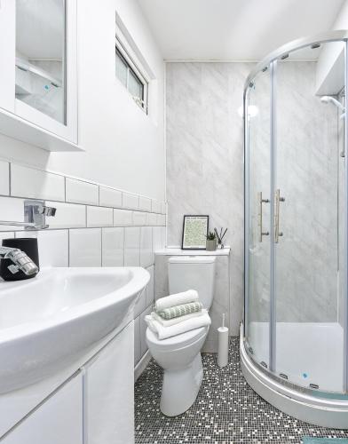 a bathroom with a toilet and a sink and a shower at The Lush Apartment Cardiff Central 2 Bedrooms in Cardiff