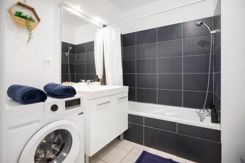une salle de bain avec un lave-linge et une baignoire dans l'établissement Le studio urbain - Parking, à Tassin-la-Demi-Lune