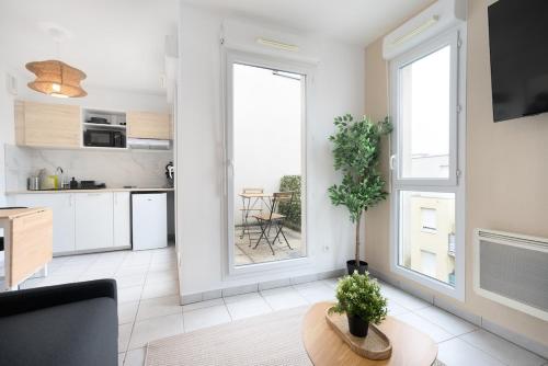 un salon avec une grande fenêtre et une table dans l'établissement Le studio urbain - Parking, à Tassin-la-Demi-Lune