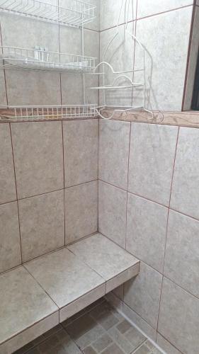 a bathroom with a tiled shower with a shelf at Casa en Punta Arenas in Punta Arenas