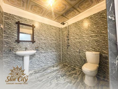 a bathroom with a toilet and a sink at SunCity Airport Transit Stay in Minuwangoda