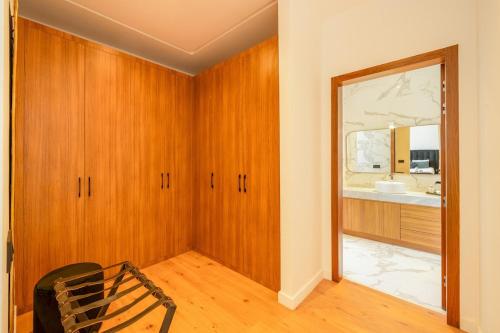 a bathroom with wooden cabinets and a mirror at Villa de standing piscine à débordement à 15 min de Marrakech in Ourika
