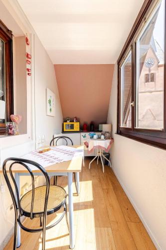 a dining room with a table and chairs and a window at Chambre du Vigneron - Domaine Léon BLEESZ in Reichsfeld