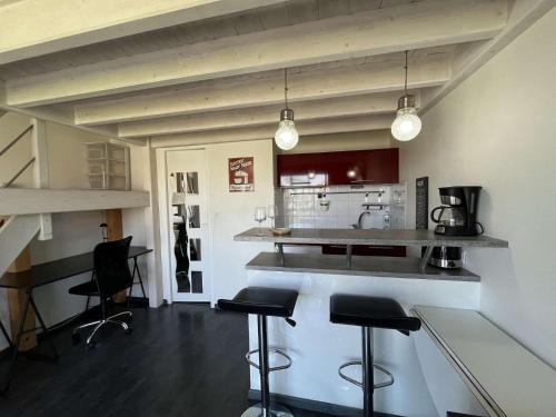 une cuisine avec un comptoir et des tabourets dans une pièce dans l'établissement Appartement de type Studio mezzanine - LR111-010, à La Rochelle