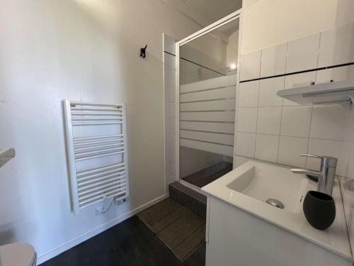 une salle de bain blanche avec un lavabo et une douche dans l'établissement Appartement de type Studio mezzanine - LR111-010, à La Rochelle