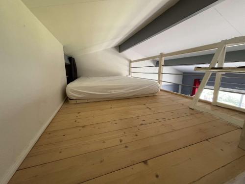 une chambre avec un lit et un parquet dans l'établissement Appartement de type Studio mezzanine - LR111-010, à La Rochelle