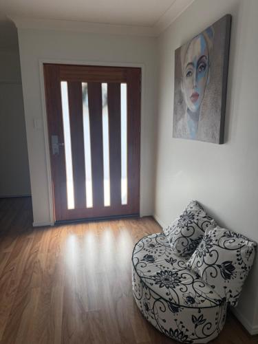 a room with a couch in front of a door at Tranquil Retreat - Your Own Room in a Peaceful Modern Shared House in Warner Lakes in Lawnton