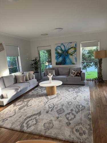 a living room with a couch and a table at Tranquil Retreat - Your Own Room in a Peaceful Modern Shared House in Warner Lakes in Lawnton