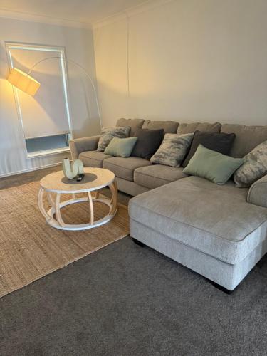 a living room with a couch and a table at Tranquil Retreat - Your Own Room in a Peaceful Modern Shared House in Warner Lakes in Lawnton