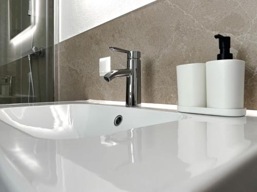a bathroom sink with a faucet and two rolls of toilet paper at Modernes Studio-Apartment in Amstetten - Ideal für paare und Alleinreisende! in Amstetten