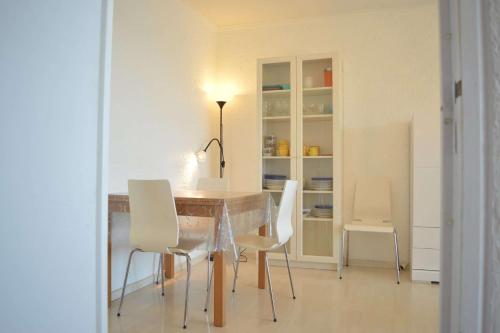 une salle à manger avec une table et des chaises blanches dans l'établissement Appart 3 pièces 6 couchages BANYULS SUR MER BN190-002, à Banyuls-sur-Mer