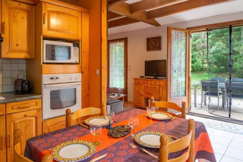 une salle à manger avec une table et des chaises et une cuisine dans l'établissement Clevacances 3 cles 4 pers au cros bas, à Chanac