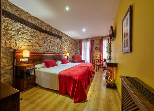 a bedroom with a bed and a stone wall at Don Pedro in Avilés