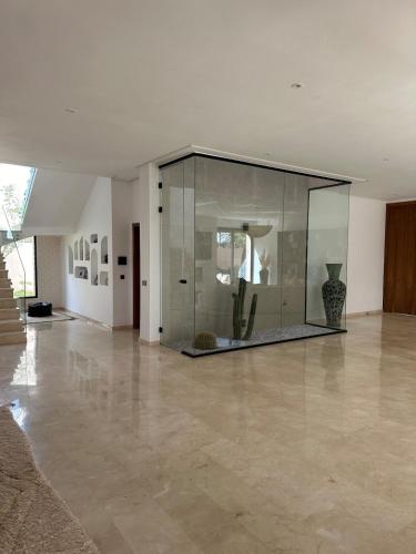 a large glass wall in a room with a floor at Villa de standing piscine à débordement à 15 min de Marrakech in Ourika