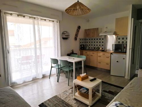 une cuisine avec une table et des chaises dans une pièce dans l'établissement Les Hauts de Perpigna, à Royan