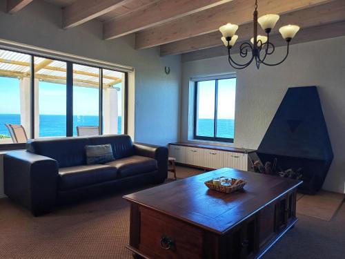 a living room with a couch and a coffee table at Whale Watch Cottage in St Helena Bay