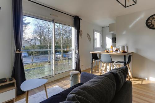un salon avec un canapé et une grande fenêtre dans l'établissement L'Escale Bretonne -Studio à 20min de Rennes centre, à Noyal-Châtillon-sur-Seich