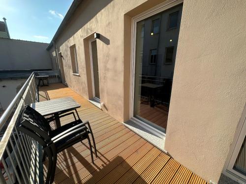 a wooden deck with a bench and a table on a balcony at Mini Apartment für 2 in Dresden