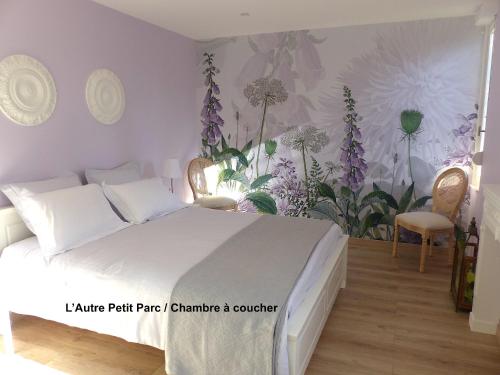 a bedroom with a bed with flowers on the wall at Le Petit Parc in Colmar