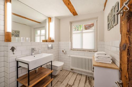 a white bathroom with a sink and a toilet at Große Use in Benz
