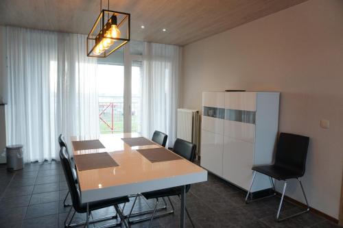 a dining room with a table and chairs and a refrigerator at Kustverhuur, Appartement aan Zee Port Scaldis 09051 in Breskens