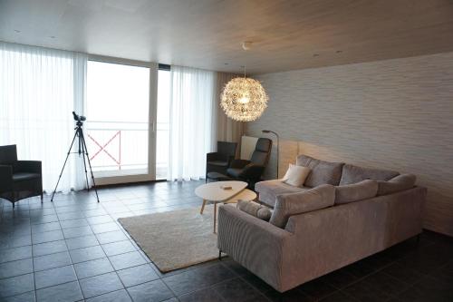 a living room with a couch and a table at Kustverhuur, Appartement aan Zee Port Scaldis 09051 in Breskens