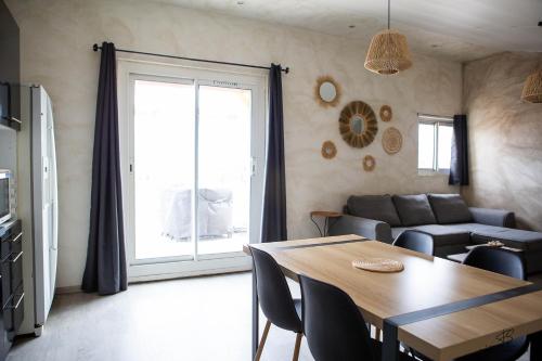 a living room with a table and a couch at Le Bel Vu - Sea view in Le Barcarès