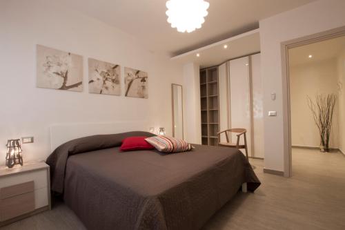 a bedroom with a bed and a chandelier at Excelsior - Via Pertini in Piombino