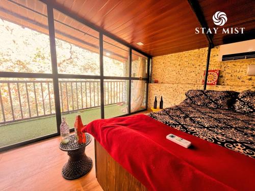 a bedroom with a bed and a large window at Mount Aurora I Stay mist in Dhamni