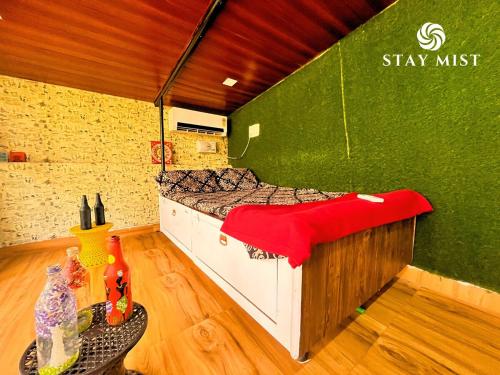 a bed in a room with a green wall at Mount Aurora I Stay mist in Dhamni