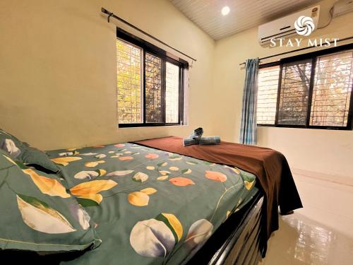 a bedroom with a bed with a leafy comforter at Mount Aurora I Stay mist in Dhamni