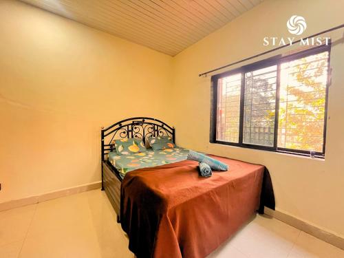 a bedroom with a bed and a window at Mount Aurora I Stay mist in Dhamni