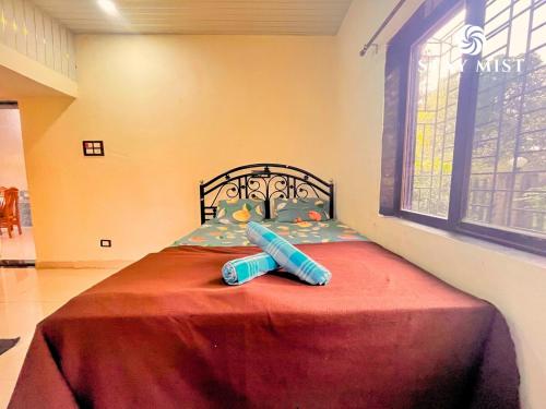 a bedroom with a bed with a red blanket and a window at Mount Aurora I Stay mist in Dhamni