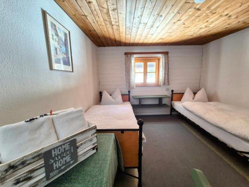 a small room with two beds and a window at Nattersbergalm in Reit im Winkl
