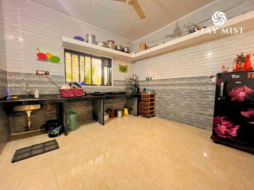 a kitchen with a table and a refrigerator in a room at Mount Aurora I Stay mist in Dhamni