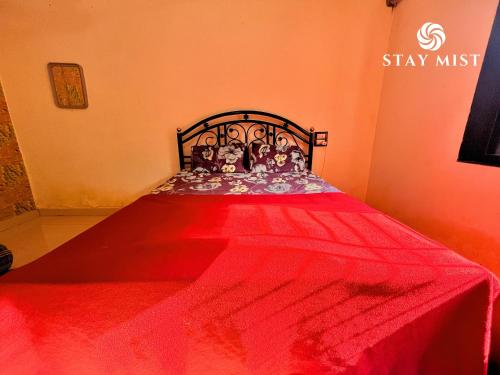 a red bed with a red blanket on it at Mount Aurora I Stay mist in Dhamni