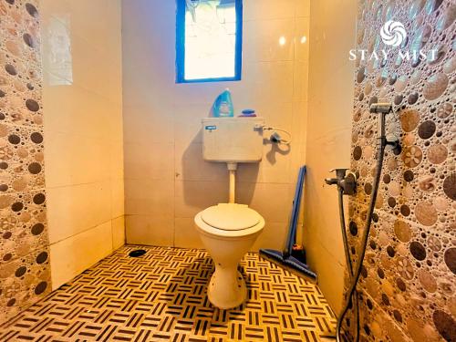 a bathroom with a toilet and a window at Mount Aurora I Stay mist in Dhamni