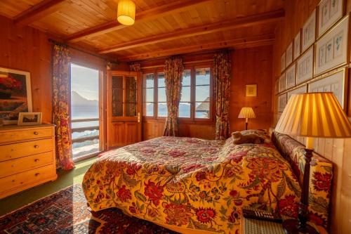 a bedroom with a bed and a large window at Chalet Bouquetins 7 personnes ski in ski out in Gryon