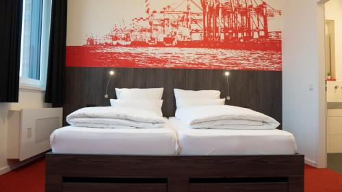 two beds in a room with a painting on the wall at havenstudios Bremerhaven in Bremerhaven
