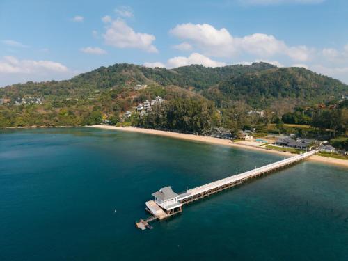 a dock in the water next to a beach at Thavorn Beach Village Resort & Spa Phuket in Kamala Beach