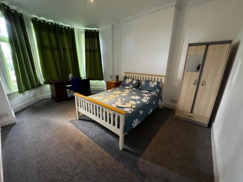 a bedroom with a bed and green curtains at Ensuite Double-Bedroom in the Heart of Salford Manchester Perfect for Short Stays GCSW2 in Manchester