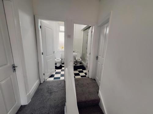 a hallway with a bathroom with two toilets and a mirror at Ensuite Double-Bedroom in the Heart of Salford Manchester Perfect for Short Stays GCSW2 in Manchester